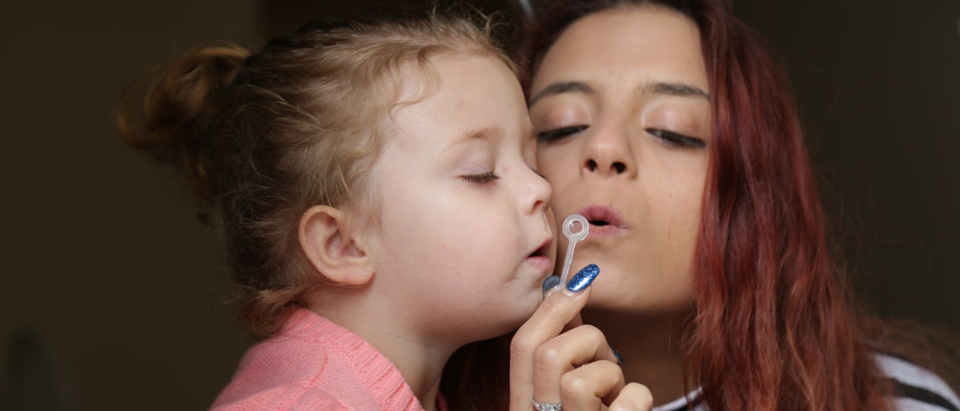 A mother and child blowing bubbles