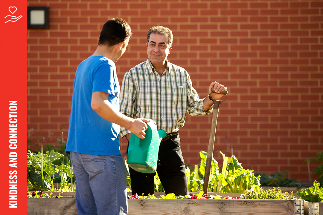 Two people talking in a garden