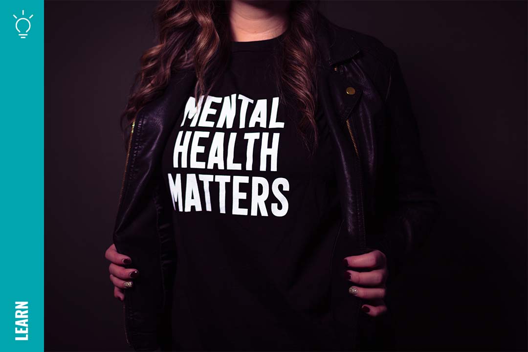A woman wears a black T-shirt reading Mental Health Matters in large white letters