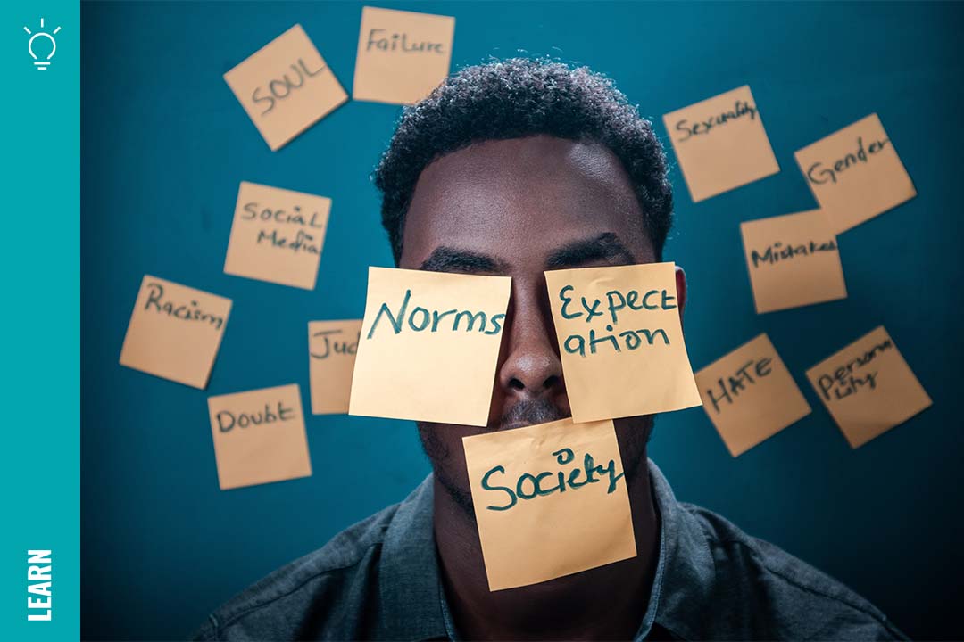 A man surrounded by sticky notes with words about race on them