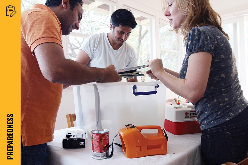 People preparing for emergency by putting items in a box