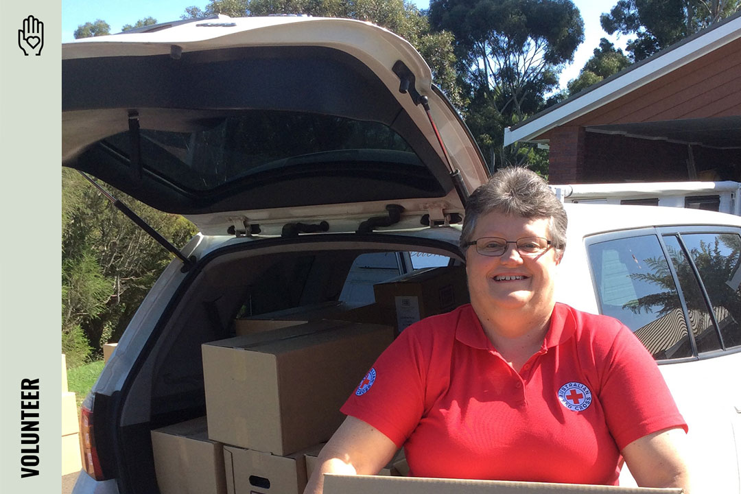 Volunteer smiling as they deliver meals