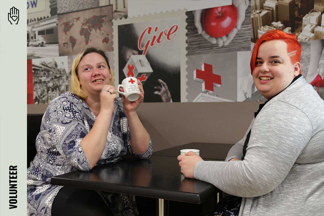 Two people at a table smiling at the camera