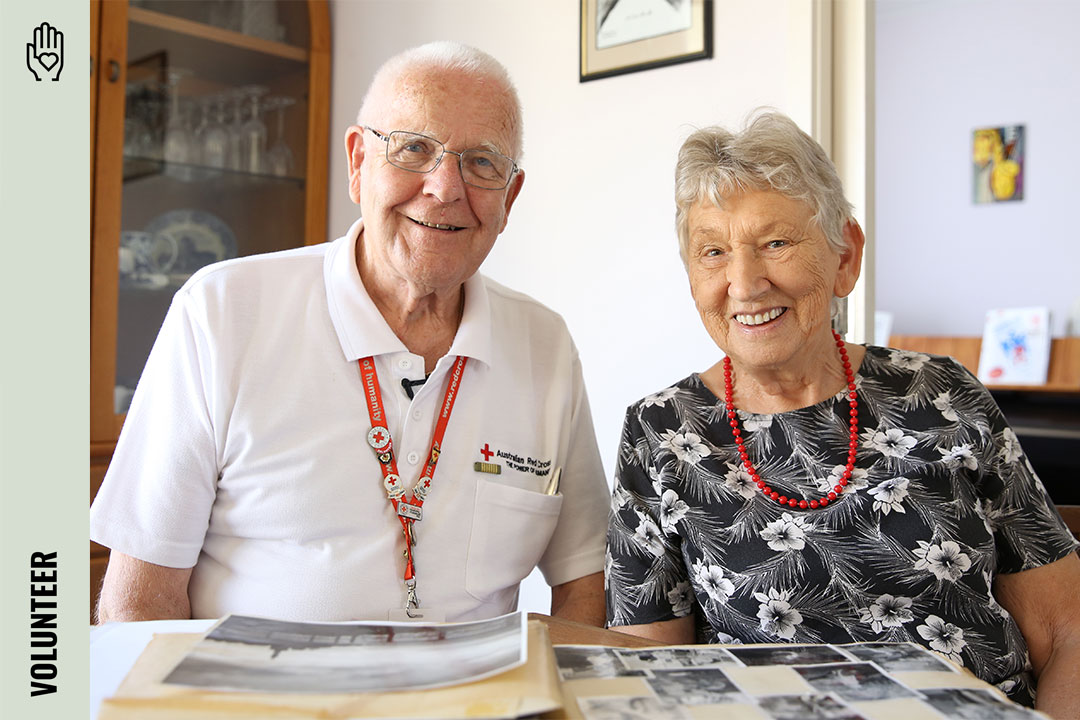 Two smiling volunteers sitting at a table