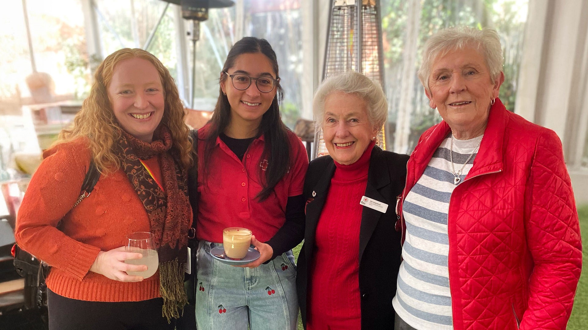 Three women, all Members od Red Cross, smile in a group photo